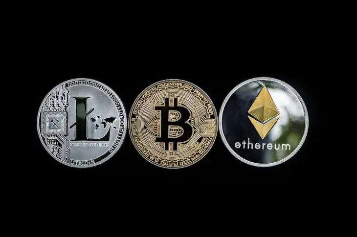 trois pièces de crypto-monnaies : litecoin, bitcoin et ethereum sur fond noir