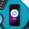 solana (sol) logo affiché sur un smartphone entouré d'outils de travail