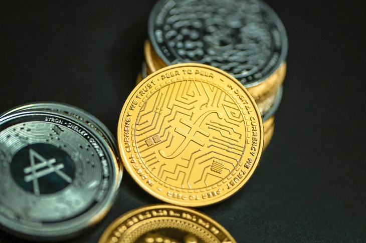 pièces de crypto-monnaies dorées et argentées sur fond noir, symboles de monnaies numériques
