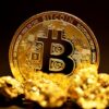 a bitcoin sitting on top of a pile of gold nuggets