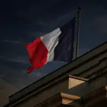 A french flag flies in the sky.