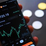 Close-up of Bitcoin trading app on smartphone showing market trends and digital coins.